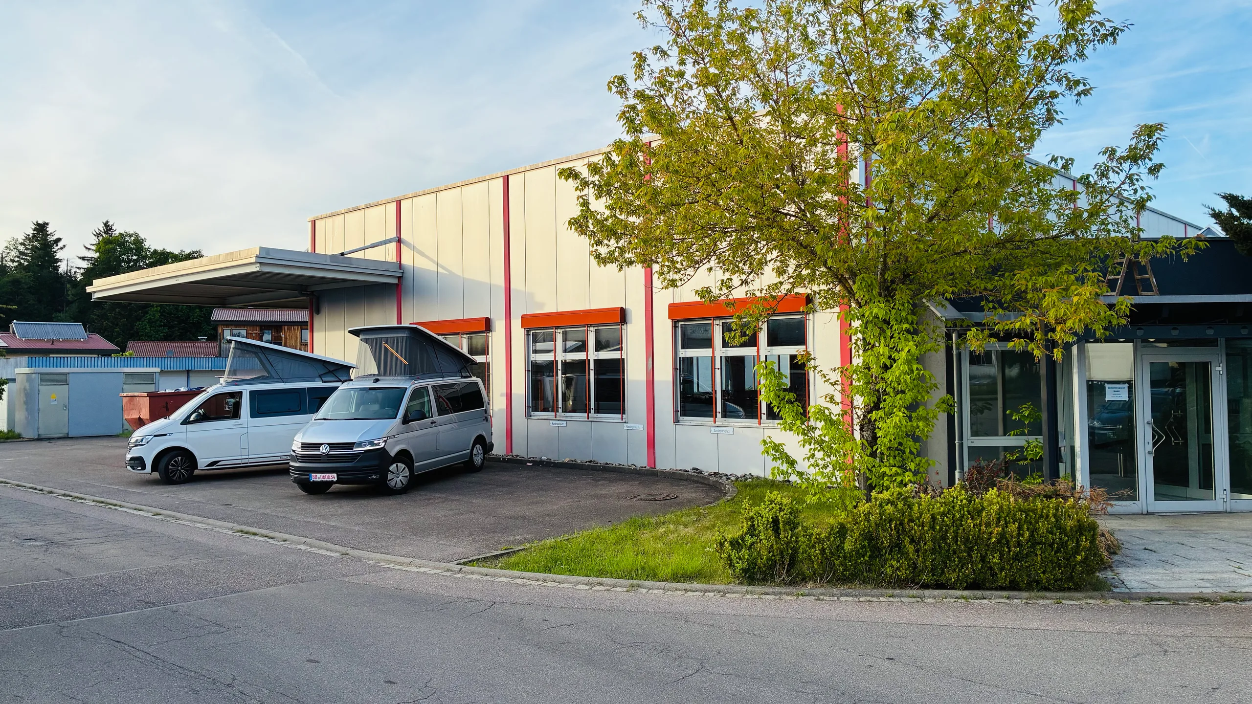 Der Standort der Demonte Caravan GmbH in Schwäbisch Gmünd; vor der Halle stehen zwei VW-Transporter-Camper mit aufgestelltem Dach