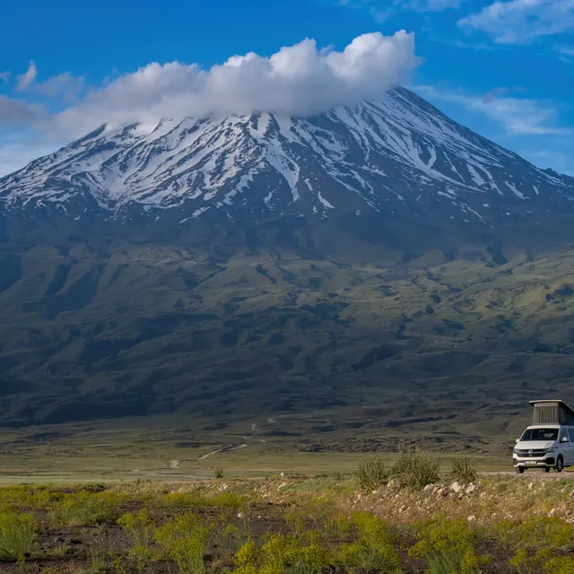 Der schneebedeckte Gipfel des Ararat über der grünen Ebene mit einem Demonte-Camper